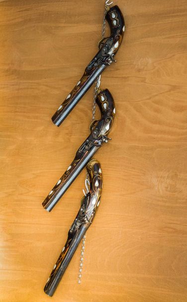 Антична стилістична револьверна гармата на дерев'яному фоні
 - Фото, зображення
