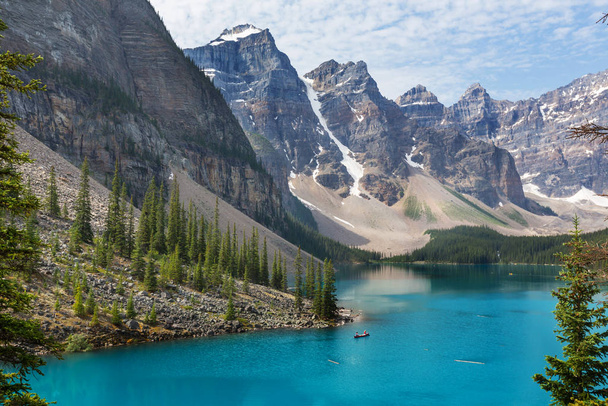 Красивые бирюзовые воды озера Морейн с заснеженными вершинами над ним в Национальном парке Банф Канады - Фото, изображение