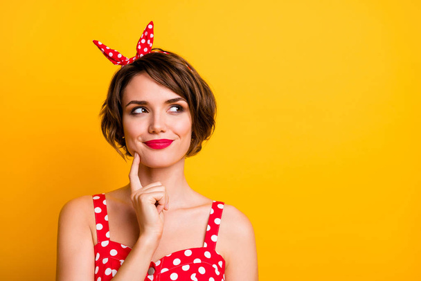 Closeup photo of pretty lady hold finger on chin look side empty space minded creative person wear retro style dotted red white tank-top headband isolated yellow color background - Φωτογραφία, εικόνα
