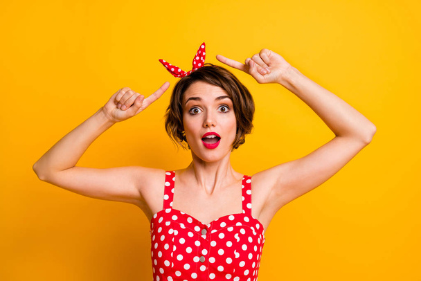 Portrait of crazy funny girl point index finger her polka-dot headband impressed scream unbelievable unexpected isolated over shine color background - Foto, afbeelding