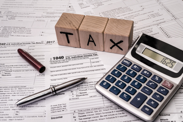 1040 individueel belastingformulier met pen en rekenmachine - Foto, afbeelding