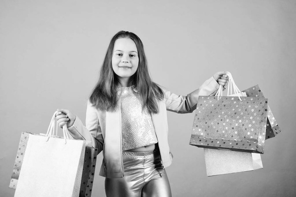 Little girl with bunch packages. Fashion girl customer. Happy child in shop with bags. Shopping day happiness. Buy clothes. Birthday girl shopping. Fashion boutique. Fashion trend. Fashion shop - Foto, Imagem