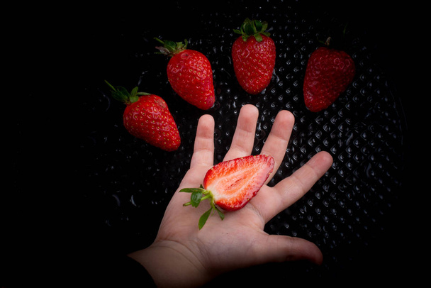 Fruta de fresa dulce y madura en mano
 - Foto, Imagen