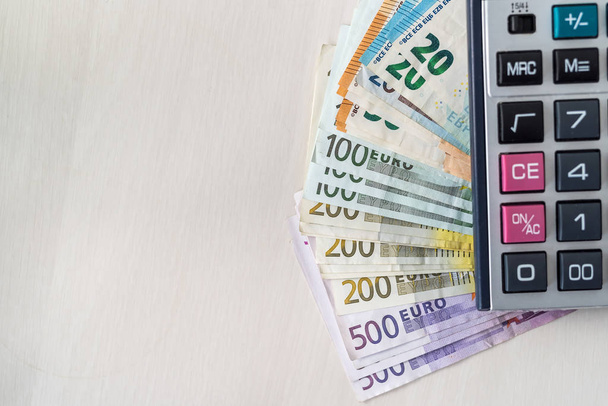 Banknoty euro z kalkulatorem na drewnianym biurku - Zdjęcie, obraz