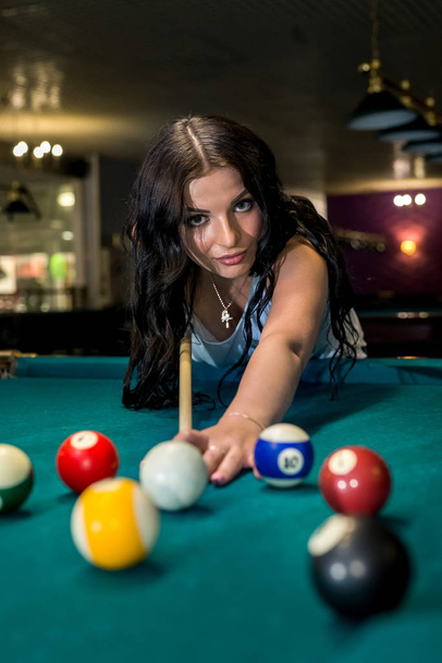 Pretty and young woman playing billiard in pub - Фото, зображення