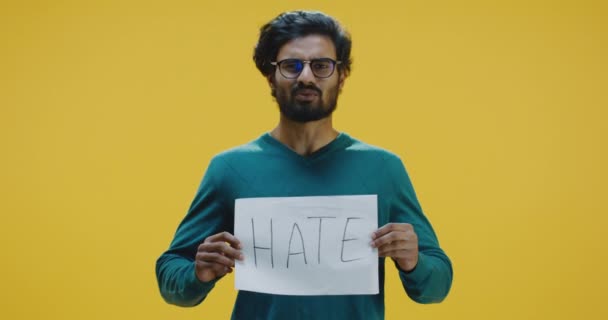 Mladý muž drží znamení nenávisti a mluví - Záběry, video