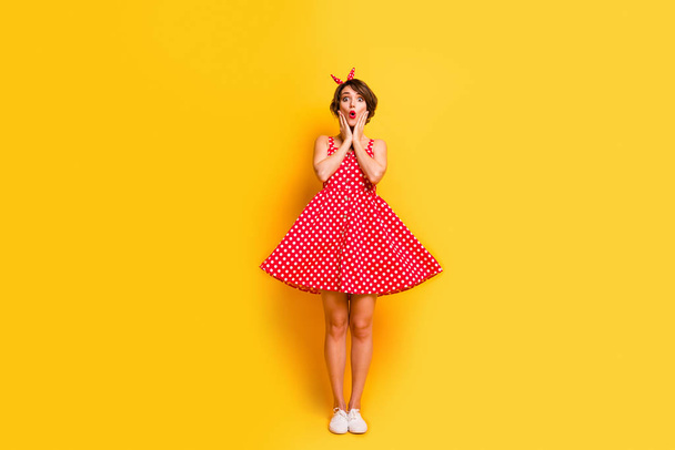 Full length photo of astonished girl relax spring rest look incredible novelty touch hands face impressed scream wear polka-dot stylish outfit shoes isolated over yellow color background - Fotó, kép