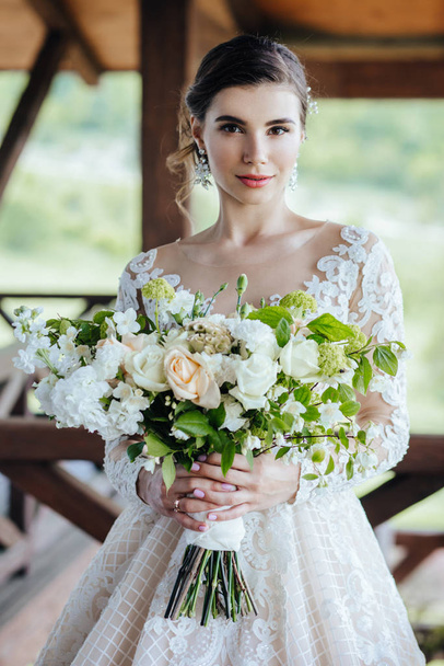 The bride in a magnificent, white, wedding dress with a wedding flowers. - Zdjęcie, obraz
