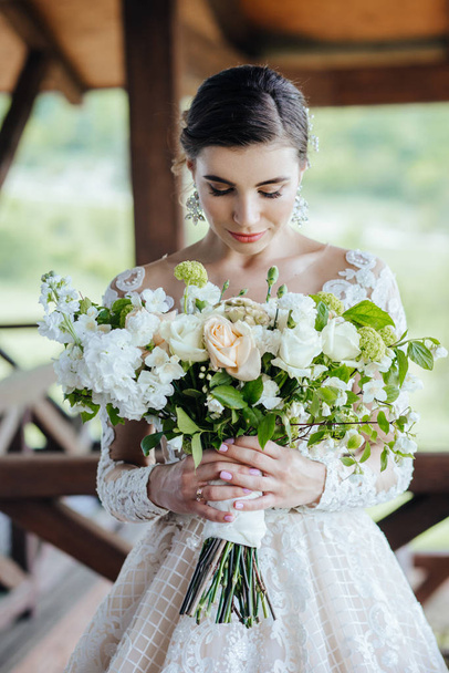 The bride in a magnificent, white, wedding dress with a wedding flowers. - Fotoğraf, Görsel