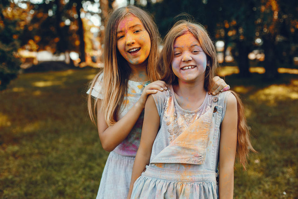 Δύο χαριτωμένα κορίτσια διασκεδάζουν σε ένα καλοκαιρινό πάρκο. - Φωτογραφία, εικόνα