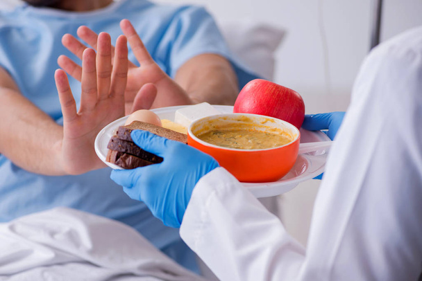 Пациент мужского пола ест пищу в больнице - Фото, изображение