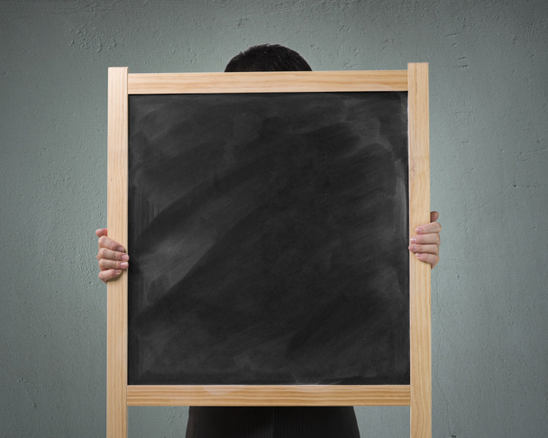 Businessman use two hands to lift up wooden blank chalk board i - Zdjęcie, obraz