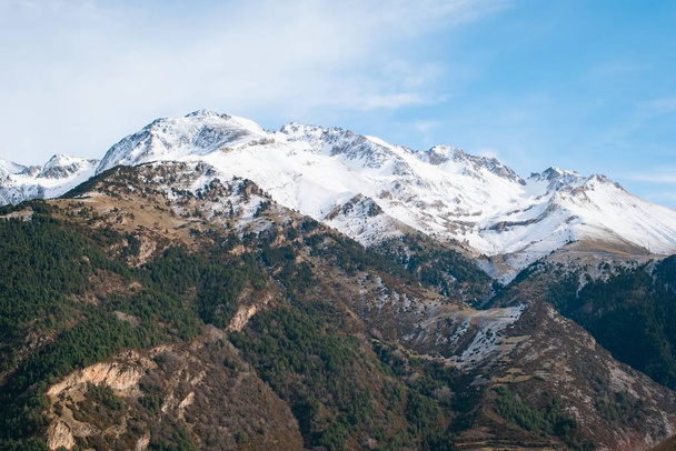 Una hermosa gama de altas montañas rocosas cubiertas de nieve durante el día
 - Foto, Imagen
