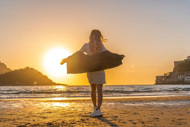 sunset portrait of beautiful young woman at sea shore - Photo, image