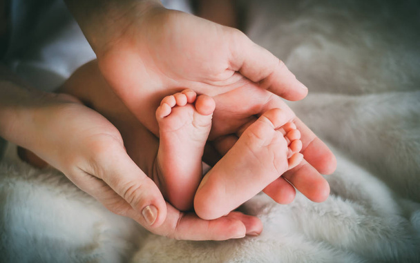 女性の手、可愛いハートのような形で生まれたばかりの赤ちゃんの足 - 写真・画像