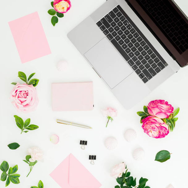 Ordinateur portable avec fleurs de roses, journal, stylo, enveloppe et pétales sur wh
 - Photo, image