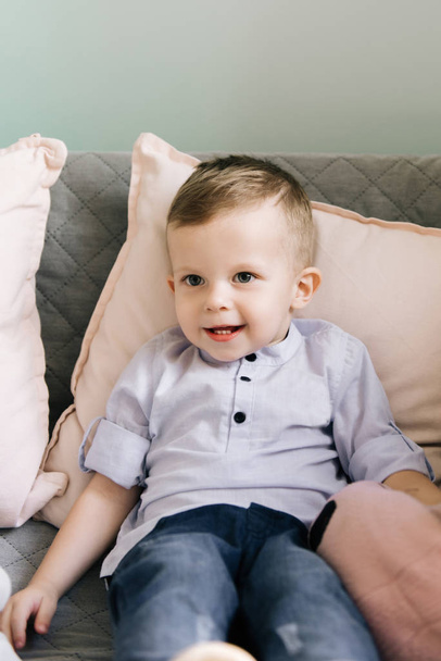 Happy stylish baby boy sitting on the sofa in a children's cafe - Φωτογραφία, εικόνα