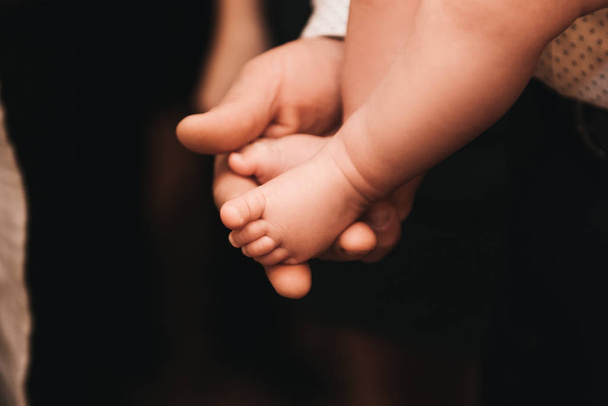 Baby feet in father hands. Tiny Newborn Baby - 写真・画像