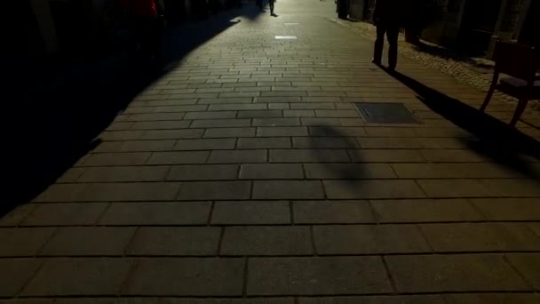 Silhouetten en schaduwen van mensen in een stad op een zonnige winterdag - Video