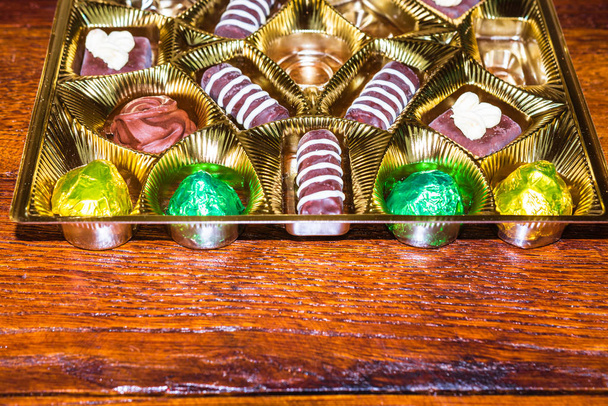 Erilaisia herkullisia suklaapraliineja kultaisessa laatikossa. Sulje u
 - Valokuva, kuva
