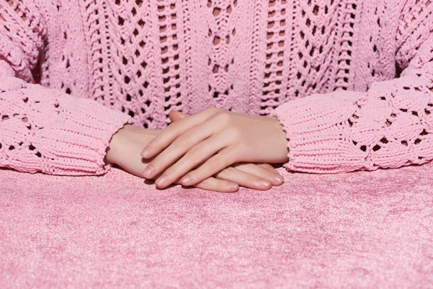 cropped view of woman with clenched hands on velour pink cloth, girlish concept  - Fotografie, Obrázek