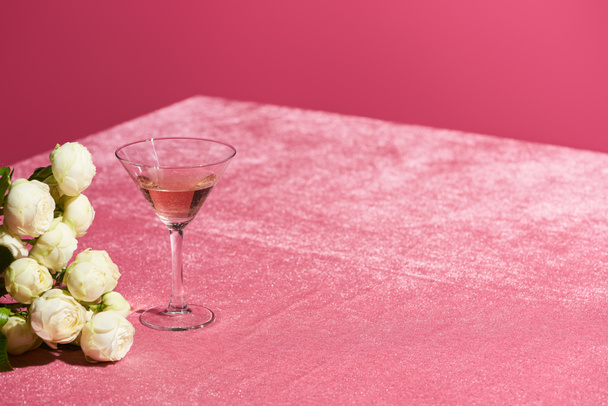 rose wine in glass near bouquet on velour pink cloth isolated on pink, girlish concept - Φωτογραφία, εικόνα