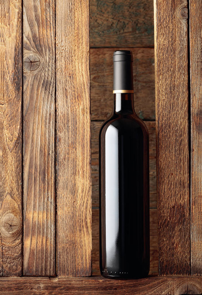 Bottle of red wine on a old wooden background.  - Fotografie, Obrázek