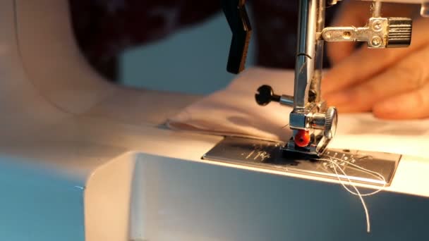 Proceso de costura - Las manos de las mujeres utilizando la máquina de coser con la luz de la lámpara incorporada, que haría la ropa textil. Aguja con bucle y prensatelas. Concepto artesanal
. - Metraje, vídeo