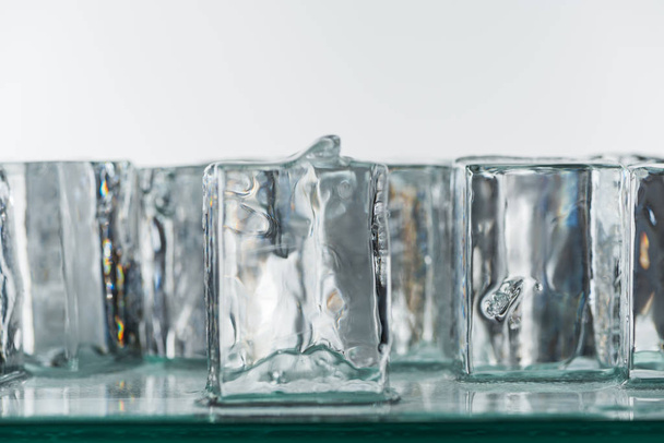 selective focus of melting transparent clear square ice cubes isolated on white - Φωτογραφία, εικόνα