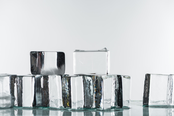 таяние прозрачных прозрачных кубиков льда, изолированных на белом
 - Фото, изображение