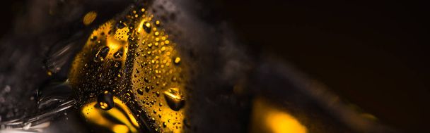 close up view of wet square ice cube with yellow illumination, panoramic shot - Photo, Image