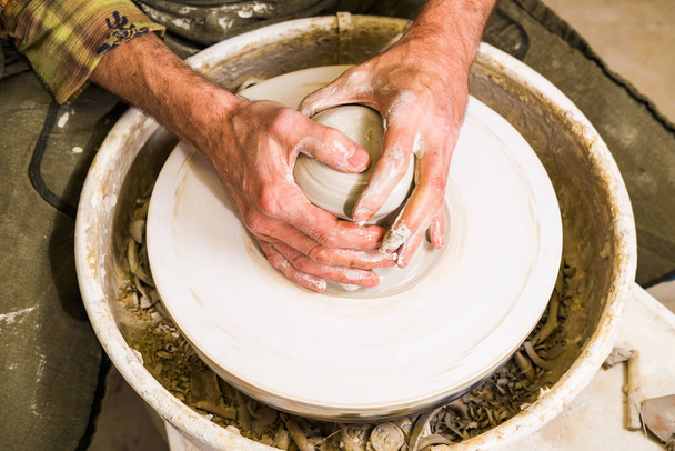 Potter haciendo tazón de barro o jarrón de cerámica en la rueda del alfarero. Creación de arte de cerámica y creación de modelos artesanales. Detalle de brazos
. - Foto, Imagen