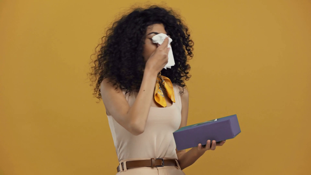 kranke zweirassige Frau niest isoliert auf dunkelgelb - Filmmaterial, Video
