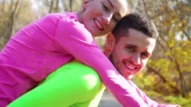 Young athletic couple in love having fun in autumn park - Metraje, vídeo
