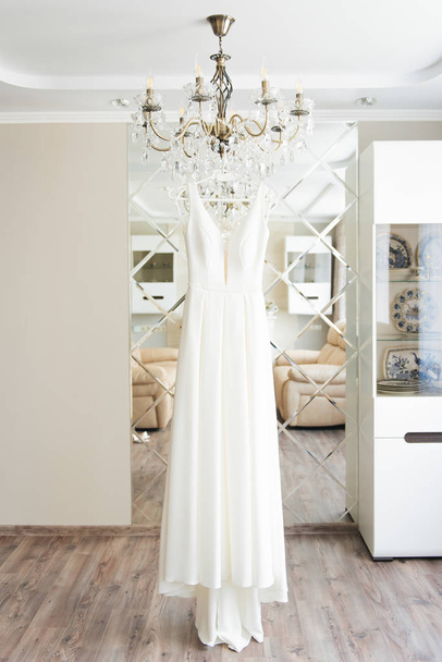 wedding dress hanging on the mirror, bride's morning - Fotó, kép