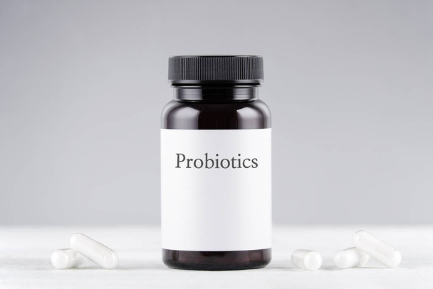 nutritional supplement probiotics bottle and capsules on gray - Foto, Imagem