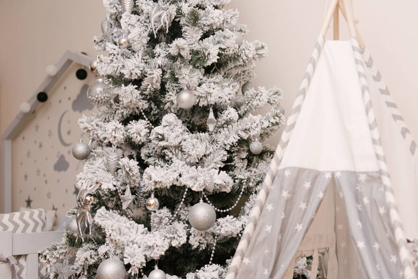 Árbol de Navidad y wigwam en habitación infantil. Decoraciones de Navidad
. - Foto, Imagen