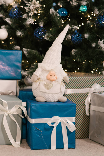 Christmas gifts and gnome under the tree, decor, selective focus - Photo, Image