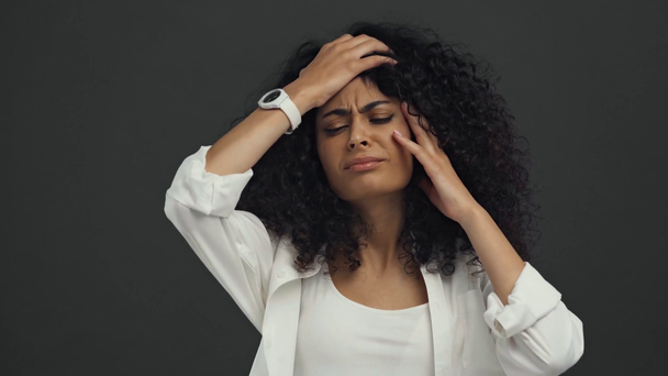 wyczerpana birasowa kobieta cierpiąca na migrenę wyizolowaną na czarno - Materiał filmowy, wideo