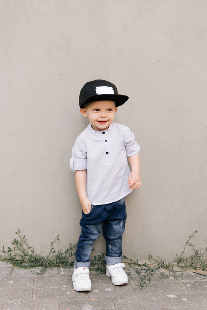 Happy stylish baby boy on grey background - Foto, imagen