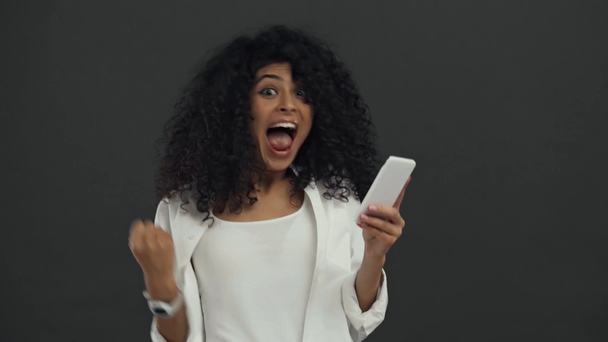 onnellinen bi-rotu nainen älypuhelin juhlii riemuvoitto eristetty musta
 - Materiaali, video