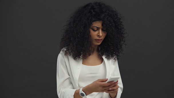 arrabbiato bi-razziale donna gettando smartphone isolato su nero
 - Filmati, video