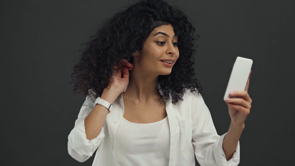 flirty bi-racial Frau winkt Hand während Videoanruf isoliert auf schwarz - Filmmaterial, Video
