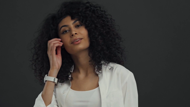flirty bi-racial Frau berührt Haare isoliert auf schwarz - Filmmaterial, Video