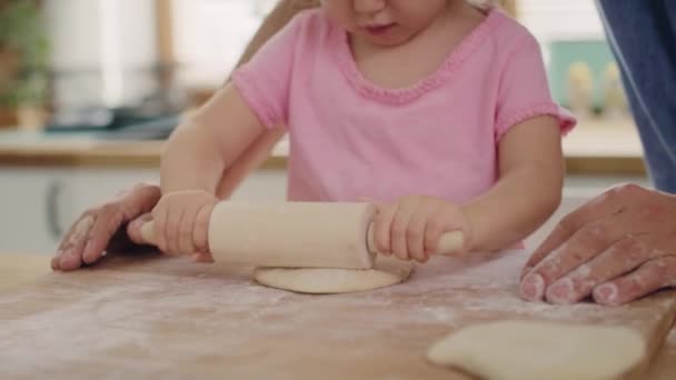 Handheld view of child rolling dough in the kitchen. Shot with RED helium camera in 8K - Footage, Video