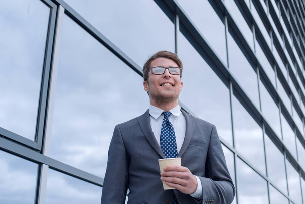 счастливый молодой бизнесмен стоит рядом с высоким офисным зданием
 - Фото, изображение