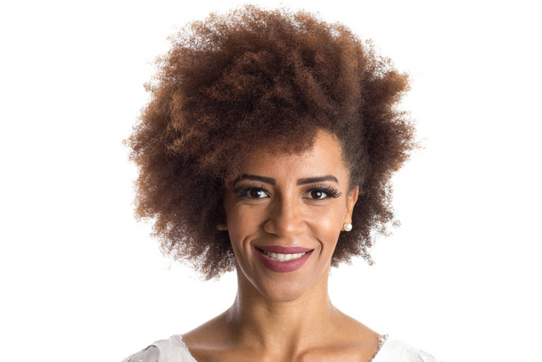 Retrato interior de una mujer afroamericana mirando felizmente a cámara. De pie sobre fondo blanco
. - Foto, Imagen
