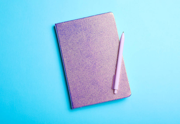 Stylish glitter notebook and pen on light blue background, top view - Фото, зображення