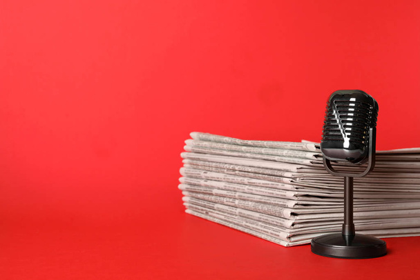 Newspapers and vintage microphone on red background, space for t - Fotografie, Obrázek