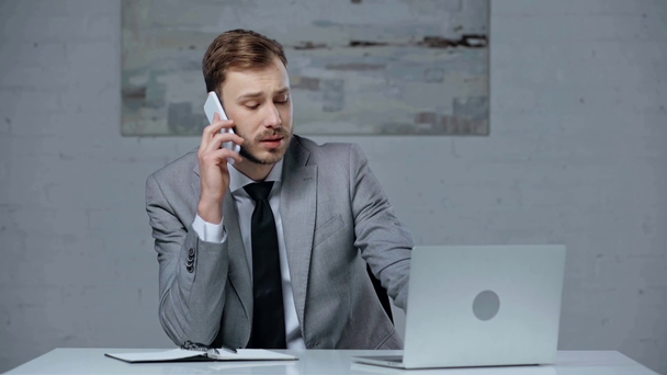 Seriöser Geschäftsmann spricht auf dem Smartphone, während er Online-Wetten abschließt - Filmmaterial, Video